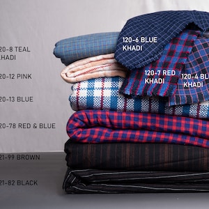 Könnte beinhalten: Ein Stapel von acht verschiedenen Stoffproben in verschiedenen Farben und Mustern, darunter Teal, Pink, Blau, Rot, Braun und Schwarz. Die Proben sind mit ihren entsprechenden Farben und Nummern beschriftet.