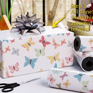 May include: A wrapped gift box with butterfly-patterned paper and a silver bow. Rolls of matching wrapping paper and scissors are nearby. Text on the image reads: "Step 3. All done! Everything is adjusted for you!"