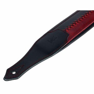 Pu&ograve; includere: Una tracolla per chitarra in pelle nera e rossa con un'estremit&agrave; a punta dotata di foro circolare, cuciture rosse decorative lungo i bordi e una sezione centrale con un motivo a punto croce rosso. Un piccolo logo &egrave; impresso sulla pelle nera.