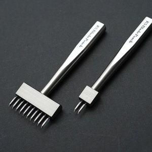 May include: Two silver leather craft tools with handles and different punch heads. The larger tool has a row of 12 sharp points and the smaller tool has two sharp points. Both tools have the text "KS Blade Punch" engraved on the handle.