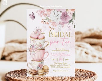 May include: A pink and white bridal shower invitation with a watercolor floral design. The invitation features a stack of teacups with macarons and the text "BRIDAL par-tea" in gold lettering. The invitation also includes the bride's name, the date, time, and location of the shower.