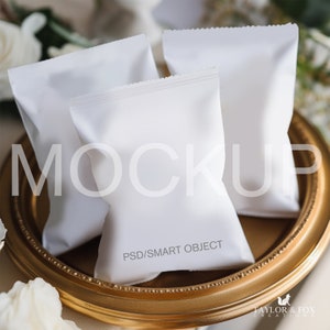 Könnte beinhalten: Drei weiße, leere Papiertüten mit goldfarbenem Rand auf einem goldenen Tablett. Der Text "PSD/SMART OBJECT" ist auf der Vorderseite der Tüte in der Mitte gedruckt.