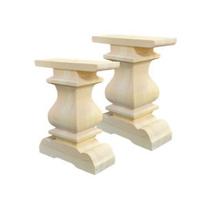 May include: Two unfinished wooden table legs with a classic pedestal design. The legs are made of solid wood and have a smooth, natural finish.