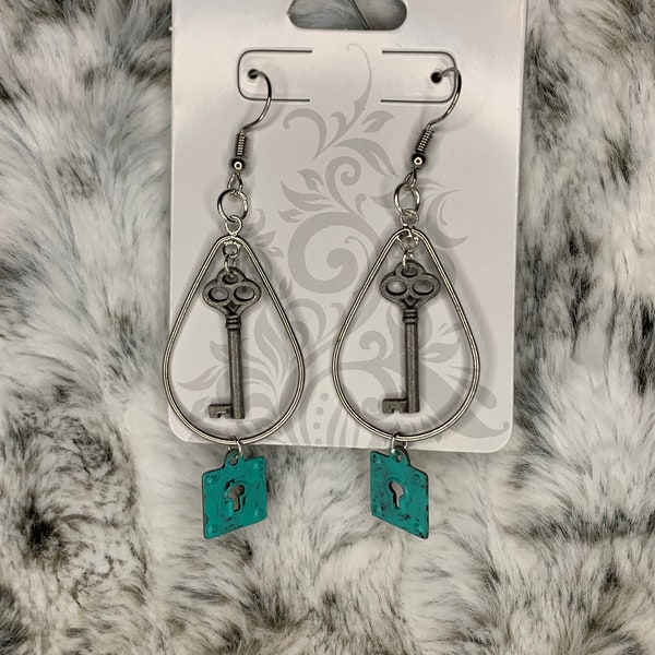 A dainty key swings from a teardrop ring with a turquoise lock at the bottom on silver fishhook -  earrings