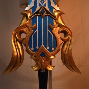 May include: A gold and blue decorative sword with intricate details. The sword has a blue blade with gold accents and a gold handle with a blue and gold design.