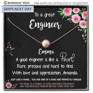 May include: A gift box containing a pearl necklace. The box has a black background with white text that reads "To a great Engineer" and "A good engineer is like a Pearl. Rare, precious and hard to find. With love and appreciation, Amanda". The box is decorated with pink flowers.