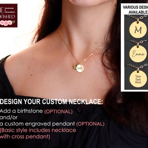 May include: A gold-toned chain necklace featuring a small cross pendant and a circular disc charm engraved with the name Emma, accompanied by a green birthstone charm. The image includes text options for custom engraving and various design styles.