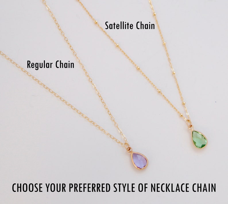Puede incluir: Se muestran dos collares dorados con colgantes en forma de l&aacute;grima, uno morado y otro verde. Los collares est&aacute;n etiquetados como "Regular Chain" y "Satellite Chain". El texto en la parte inferior dice: "CHOOSE YOUR PREFERRED STYLE OF NECKLACE CHAIN."