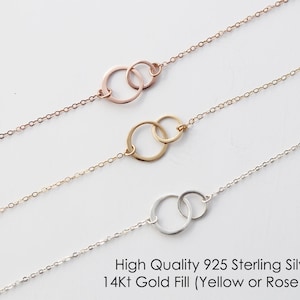May include: Three delicate necklaces with interlocking circle pendants. The necklaces are available in sterling silver, yellow gold fill, and rose gold fill.