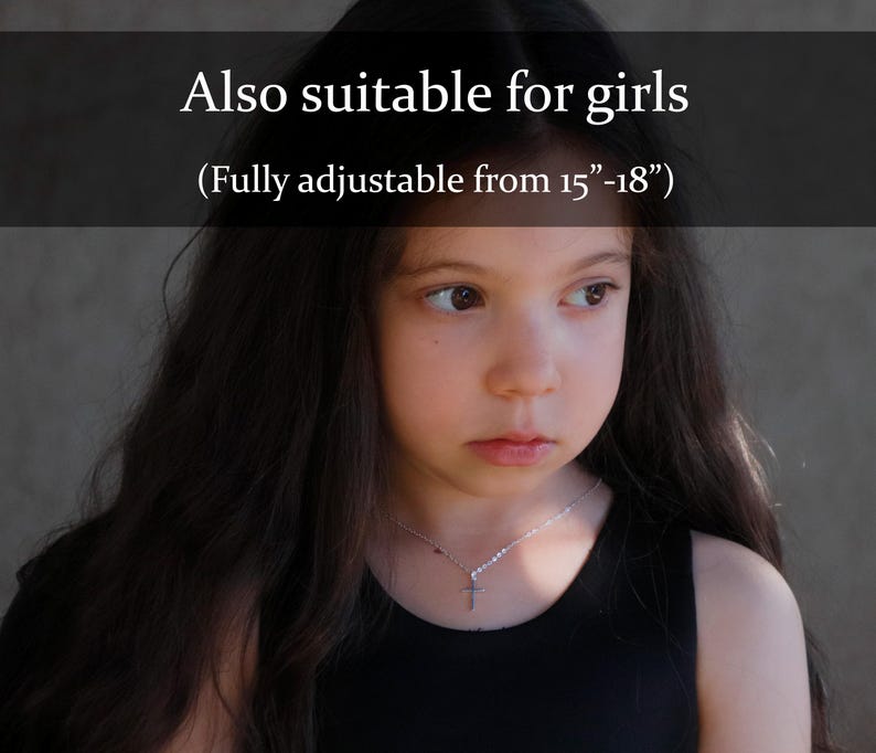 Puede incluir: Un collar de cruz plateada en una persona joven. El collar es totalmente ajustable de 38 a 46 cm. El texto de la imagen dice "Also suitable for girls".