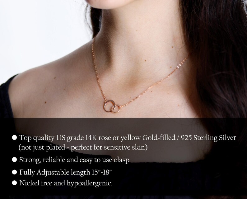 May include: A rose gold-colored necklace featuring two interlocking circular rings as a pendant on a delicate chain. The text states: Top quality US grade 14K rose or yellow Gold-filled / 925 Sterling Silver, strong, reliable and easy to use clasp, fully adjustable length 15-18 inches, nickel free and hypoallergenic.