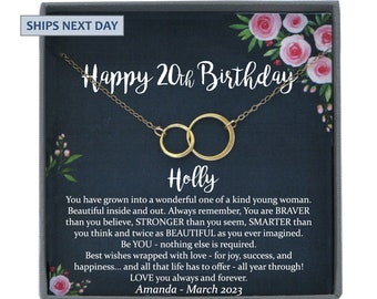 May include: A gold-colored necklace with two interlocking circular pendants presented in a dark gray gift box. The card inside features pink floral illustrations and text that reads Happy 20th Birthday, Holly, and a message about being brave and strong.