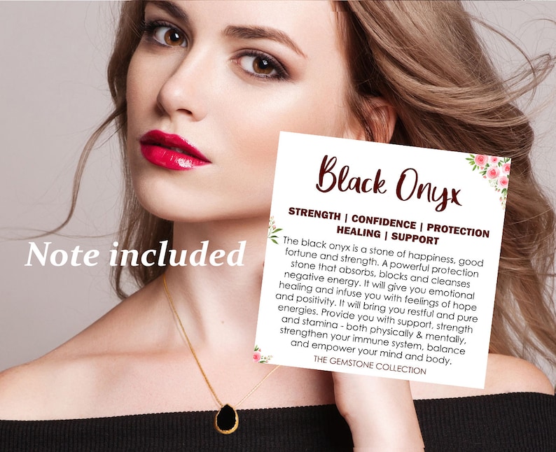 K&ouml;nnte beinhalten: Ein tropfenf&ouml;rmiger schwarzer Onyx-Anh&auml;nger an einer d&uuml;nnen Goldkette. Eine quadratische wei&szlig;e Karte ist enthalten mit dem Text Black Onyx, Strength, Confidence, Protection, Healing, Support und einem Text &uuml;ber die Steineigenschaften.