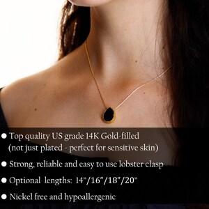 May include: A gold-filled necklace with a black teardrop-shaped pendant. The necklace has a delicate chain and a lobster clasp. Optional lengths are 14", 16", 18", and 20". The necklace is nickel-free and hypoallergenic.