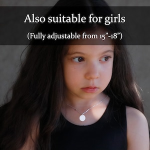 May include: A silver-toned chain necklace featuring a small, circular pendant. The text "Also suitable for girls (Fully adjustable from 15"-18")" is overlaid on the image. The necklace has a delicate link design and a smooth, polished finish.