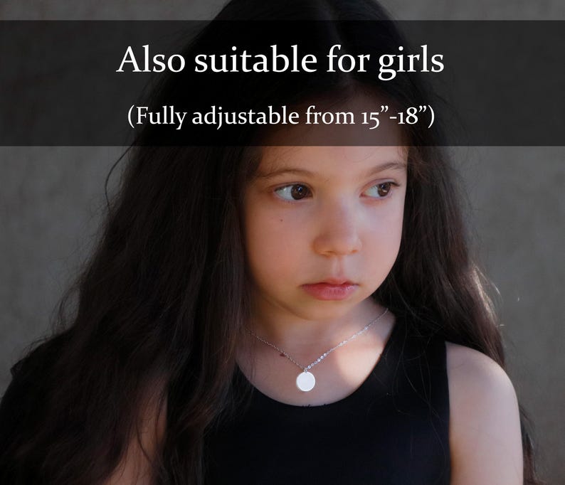 May include: A silver-toned chain necklace featuring a small, circular pendant. The text "Also suitable for girls (Fully adjustable from 15"-18")" is overlaid on the image. The necklace has a delicate link design and a smooth, polished finish.