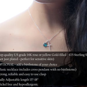May include: A silver necklace with a cross pendant and a small blue heart-shaped charm. The necklace is shown on a person's neck. The chain is adjustable from 15 to 18 inches.