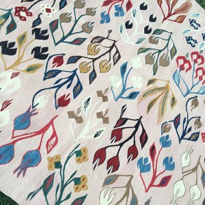 Puede incluir: Una alfombra rosa con un patr&oacute;n floral. La alfombra presenta una variedad de colores, incluyendo rojo, azul, verde y amarillo. Las flores son estilizadas y tienen un toque caprichoso.