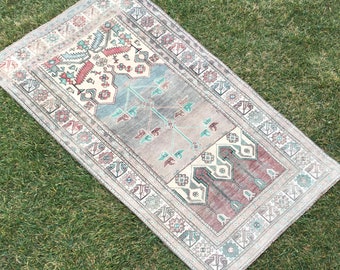 May include: A vintage Turkish rug with a traditional geometric pattern in shades of pink, blue, and green. The rug has a faded, distressed look and is perfect for adding a touch of bohemian style to any room.