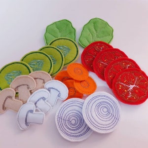Puede incluir: Conjunto de juego de comida de fieltro con varias verduras y champi&ntilde;ones. El conjunto incluye dos hojas de lechuga verdes, cuatro rodajas de zanahoria naranja, cinco rodajas de tomate rojo, cuatro rodajas de champi&ntilde;&oacute;n blanco y dos rodajas de cebolla blanca.