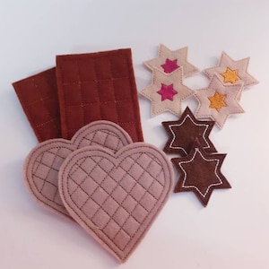 Puede incluir: Un conjunto de piezas de fieltro para una actividad de juego para ni&ntilde;os. El conjunto incluye dos rect&aacute;ngulos marrones, dos formas de coraz&oacute;n de color marr&oacute;n claro y cinco formas de estrellas de varios colores, incluyendo marr&oacute;n, rosa y amarillo.