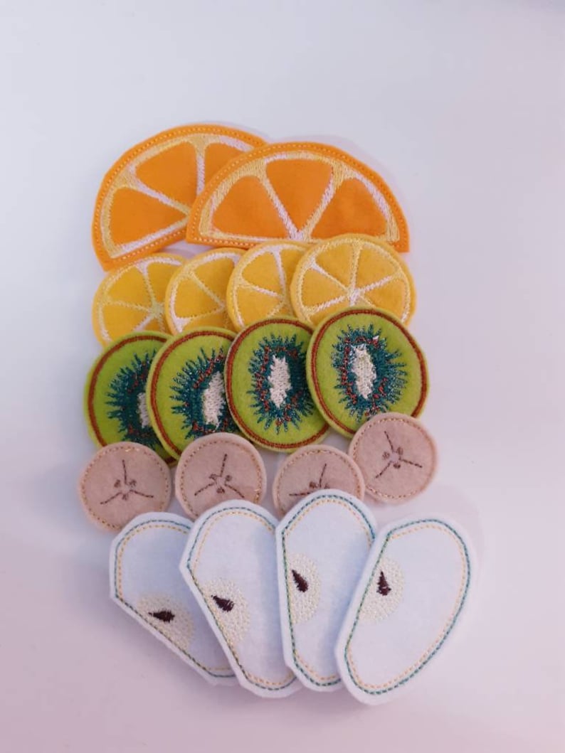 Puede incluir: Un conjunto de aplicaciones de fruta de fieltro, que incluyen rodajas de naranja, rodajas de kiwi y rodajas de pera. Las aplicaciones son perfectas para proyectos de manualidades, como coser, scrapbooking y hacer tarjetas.