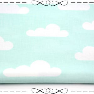 Könnte beinhalten: Ein hellblauer Stoff mit einem weißen Wolkenmuster. Der Stoff ist in der Mitte gefaltet und hat eine weiche, strukturierte Oberfläche.