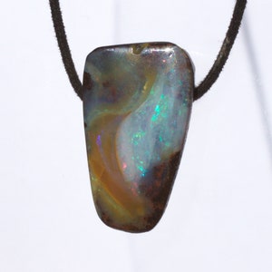 Opal pendant in freeform ground and drilled sideways with leather strap