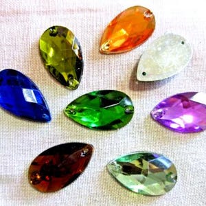 Può includere: Assortimento di otto strass di vetro a forma di goccia in vari colori, tra cui verde, blu, viola, arancione e trasparente.