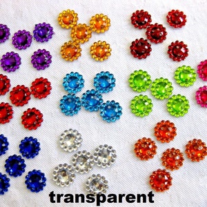 May include: Assortment of colourful, round, flat-backed embellishments with a scalloped edge. The embellishments are in various colours, including red, orange, yellow, green, blue, purple, and silver. The embellishments are arranged in a circular pattern on a white background. The word "transparent" is written in black letters at the bottom of the image.