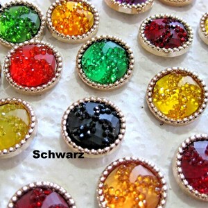 Könnte beinhalten: Sortiment runder, glitzernder Knöpfe mit goldener Einfassung. Die Knöpfe sind in verschiedenen Farben, darunter Rot, Grün, Gelb und Schwarz. Der Text "Grün2" und "Schwarz" ist im Bild sichtbar.