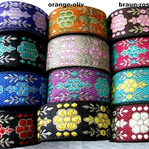 May include: Twelve rolls of decorative trim with a floral pattern. The trim is in various colours, including purple, orange, brown, pink, blue, turquoise, yellow, red, and white. The trim has a gold metallic thread woven into the design.