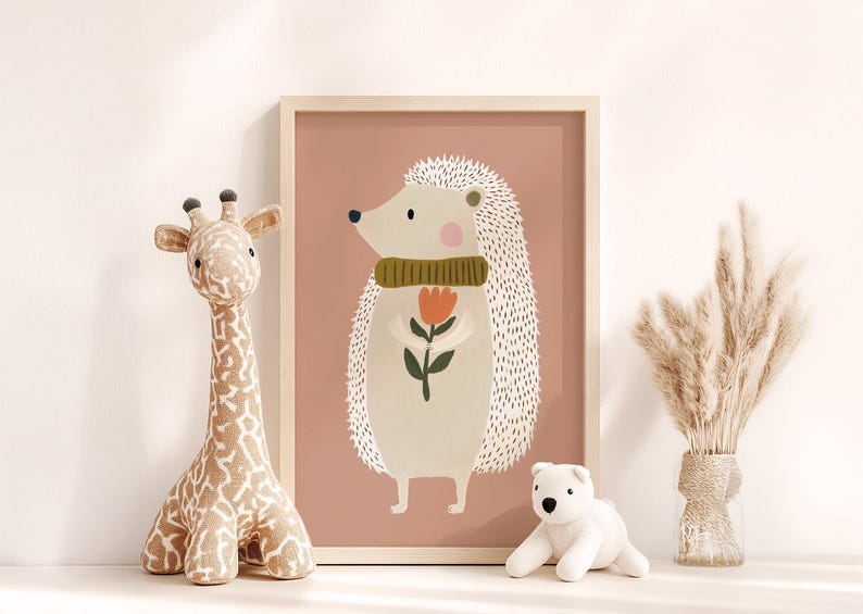 May include: A framed illustration of a hedgehog wearing a green scarf and holding a flower. A stuffed giraffe and a white polar bear toy are on the left and right. A vase of dried pampas grass is on the right.
