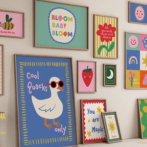 May include: A selection of framed art prints with colourful illustrations. The prints depict a bee, crab, duck, strawberry, and other fun images. Text includes "Bloom Baby Bloom", "Cool Quacks Only", and "You are Magic".