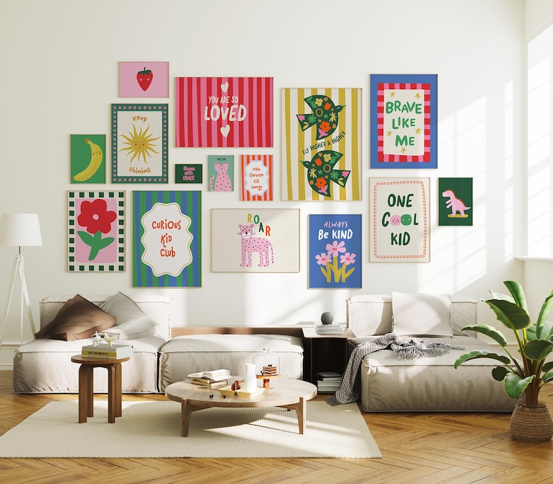 May include: A gallery wall of framed art prints with bright colours and cheerful designs. The prints include images of a banana, sun, flowers, and a dinosaur, with phrases such as "Curious Kid Club" and "Always Be Kind".