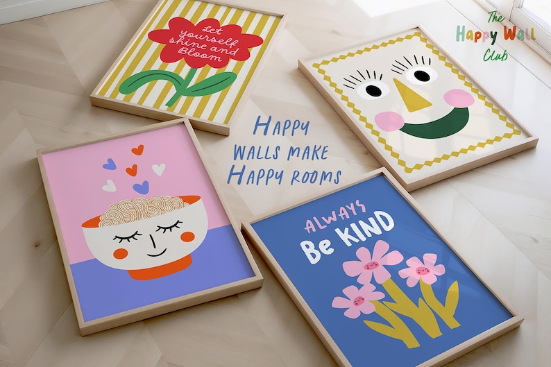 May include: Four framed art prints with cheerful designs. One shows a red flower with the text "Let yourself shine and Bloom." Another has a smiling face. The third has a bowl with a face, and the fourth says "Always Be Kind" with flowers. The text "Happy Walls Make Happy Rooms" is also visible.