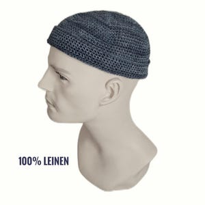 Könnte beinhalten: Eine dunkelgraue, gehäkelte Mütze mit umgeschlagenem Rand, präsentiert auf einem Schaufensterpuppenkopf. Die Mütze hat ein strukturiertes Webmuster. Der Text 100% LEINEN ist in Dunkelblau unten links im Bild aufgedruckt.