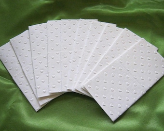 May include: A stack of white tissue paper with a heart pattern. The tissue paper is folded in a fan shape.