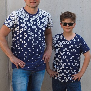 May include: Two people wearing matching navy blue t-shirts with a white geometric pattern. The shirts have a crew neck and short sleeves. The people are wearing blue denim shorts and sunglasses.