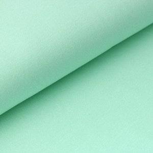 Könnte beinhalten: Nahaufnahme eines hellgrünen Stoffes mit glatter Textur.