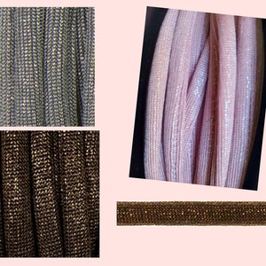 Könnte beinhalten: Nahaufnahme von drei verschiedenen Farben von glitzerndem, metallischem, gewebtem Stoff. Die Farben sind Silber, Braun und Rosa.