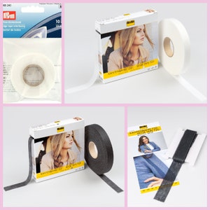 Könnte beinhalten: Zwei Rollen weißes und schwarzes Bügelband für Nähprojekte. Das Band ist 120 mm breit und mit "KANTENBAND 120 EDGE TAPE 120" beschriftet.