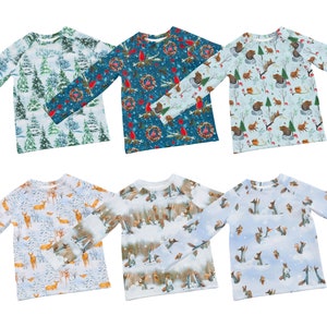 以下が含まれることがあります： 冬をテーマにした異なるパターンが施された長袖シャツ6枚。シャツには、青、緑、赤、白の色合いで、木、リース、鳥、動物のデザインが施されています。