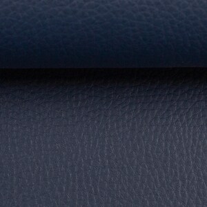 May include: A close-up shot of a navy blue leather surface with a textured finish. The leather displays a fine grain pattern and a matte appearance. A darker band divides the image horizontally, creating a contrast in tone.