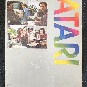 May include: A vintage Atari Home Computer Product Catalog with a light gray cover. The front features the text ATARI in a vertical rainbow gradient, along with four photographic insets showing people using Atari computers and the title text.