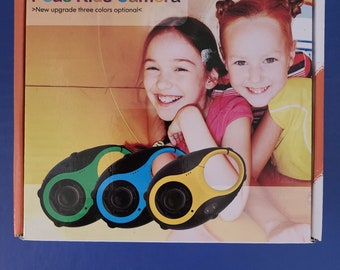 May include: A box for a Peas Kids Camera with the text "Peas Kids Camera" and "New upgrade three colors optional". The box shows two children smiling and three cameras in green, blue, and yellow.