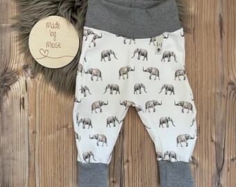 Könnte beinhalten: Weiße Babyhose mit grauem Bund und Elefantenprint. Die Hose hat den Text "Made by Meise" auf einem Holzschild.