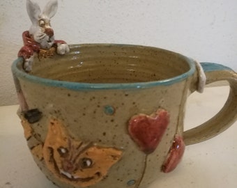 Tasse mit “Alice im Wunderland“- Motiven und  einem modelliertem Hasen am Rand, Steinzeug, Unikat, Handgefertigt, Handwerk, Aussergewöhnlich