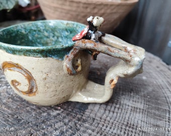 Unusual cup in the shape of a snail with a modeled ladybug on the edge. A fun and handmade unique piece in stoneware quality, great!