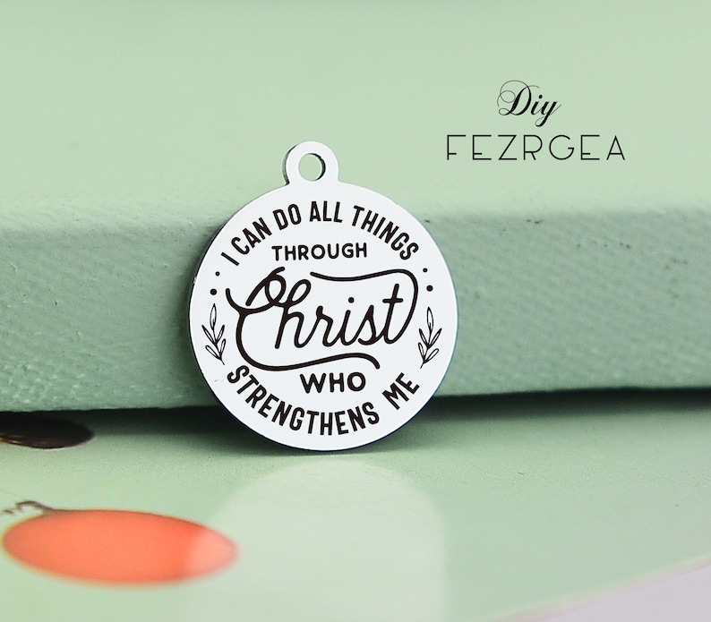 May include: A silver charm with the text "I can do all things through Christ who strengthens me" in black lettering.